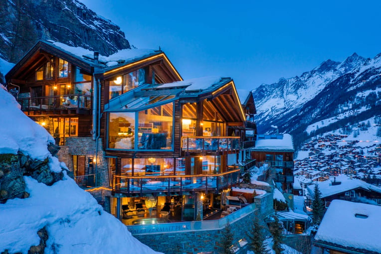 Chalet Zermatt Peak, Švýcarsko – Zermatt | Exclusive Tours Chalet evening lit up looking towards Täsch