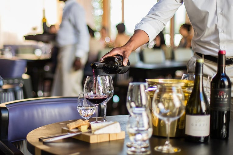 Delaire Graff Estate | Excluaive Tours a-waiter-pouring-red-wine-at-Delaire-Graff-Estate-wine-tasting-lounge